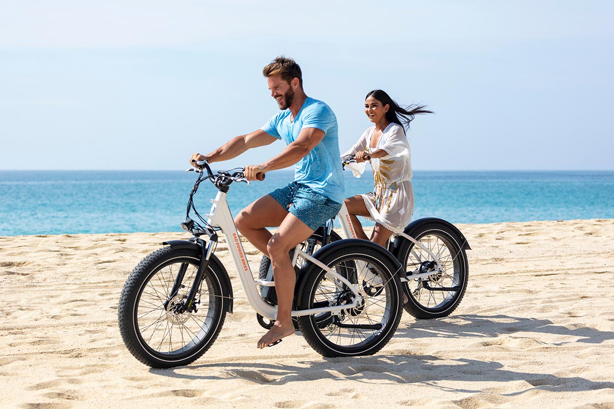 Happy couple in a beach bicycle tour 