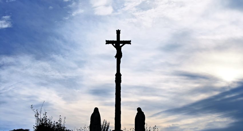 Silhouettes of a crucifix with statues of Virgin Mary and Joseph seen in Normandy,France.